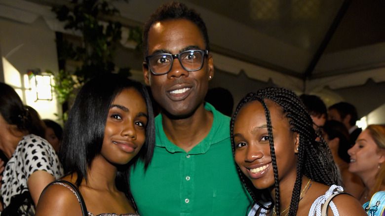 Chris Rock lächelt neben seinen beiden Töchtern
