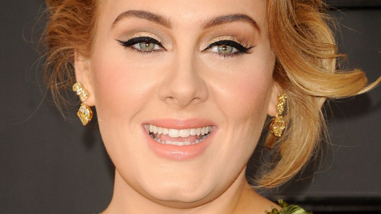 Adele mit breitem Lächeln und Hochsteckfrisur bei den Grammy Awards