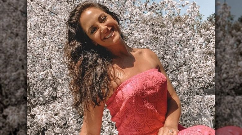 Emily Compagno posiert für Kameras vor Kirschblüten